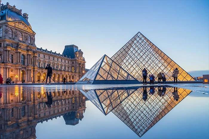 le Louvre à Paris se reflète dans une flaque d'eau