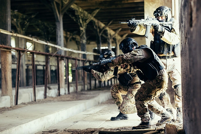 tři vybavení airsofťáci jsou v uzavřené místnosti