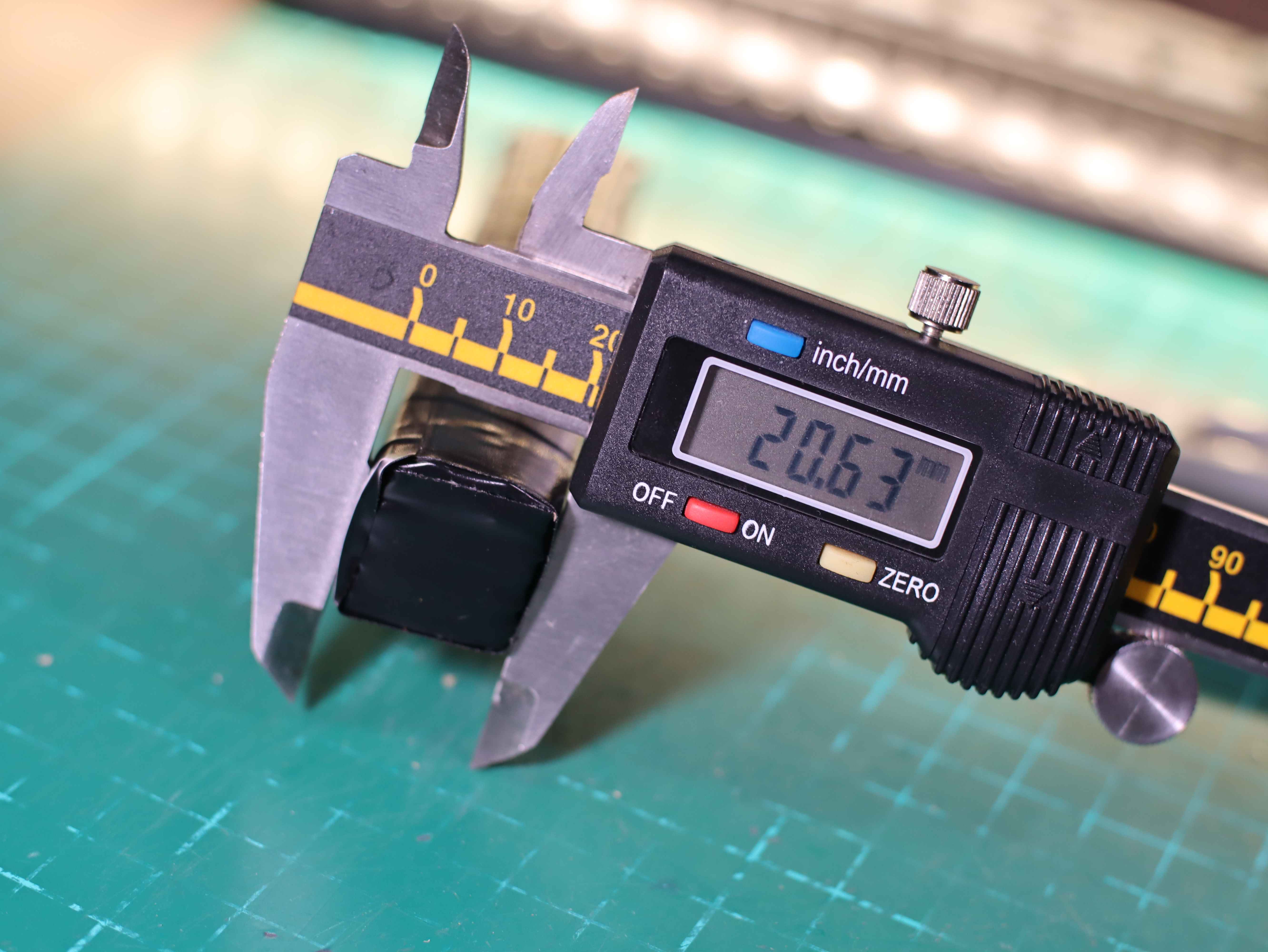 Re-measure the thickness of the battery from the cardboard. Electronic caliper and model covered with insulating tape.