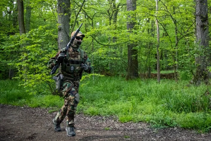 Running airsoft player in the woods