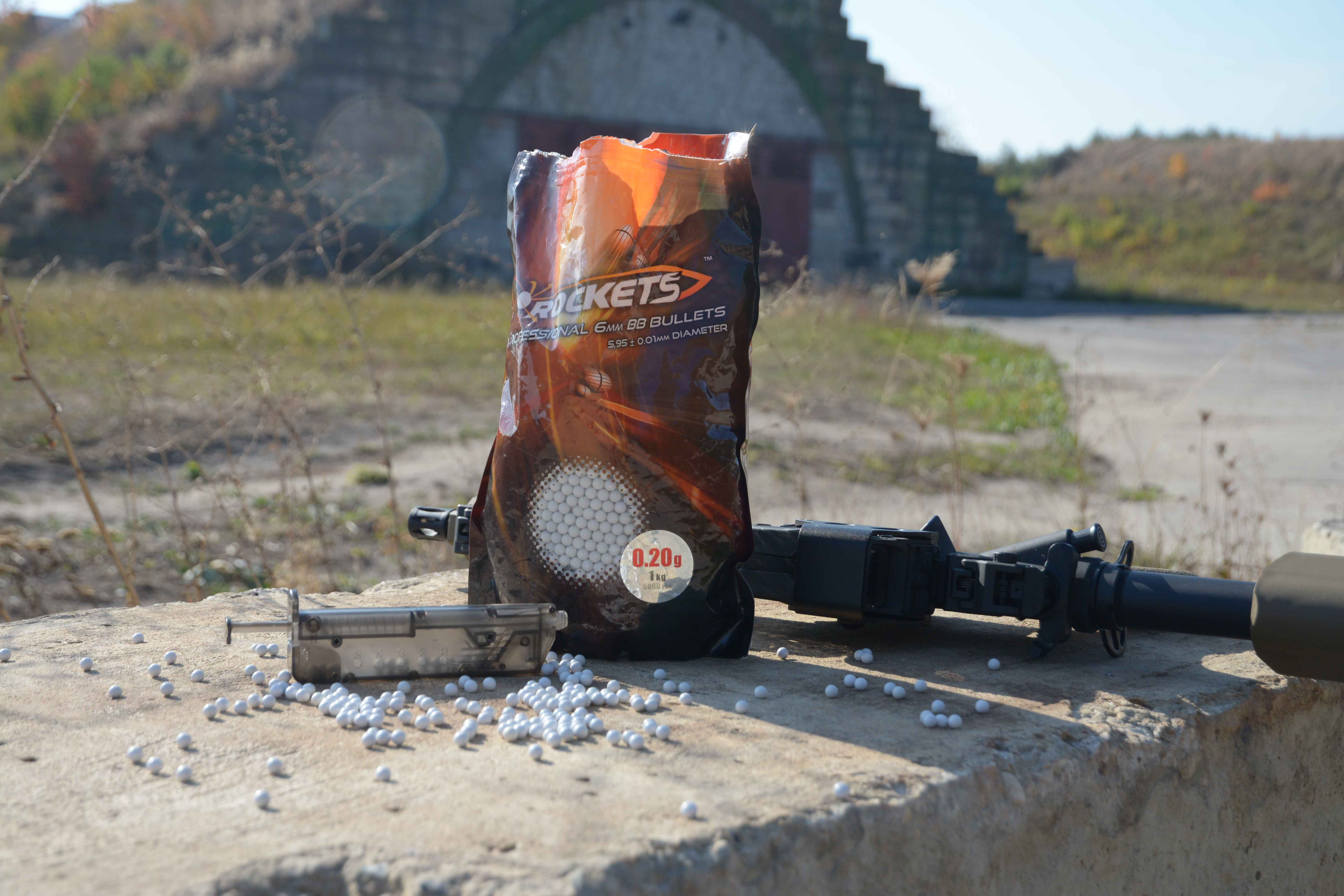 kulki airsoft do replik; rockets; paczka stojąca na bloczku obok repliki